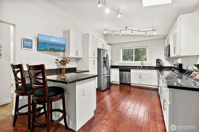 Updated kitchen is sleek and modern.  Plenty of space for too many cooks in the kitchen!
