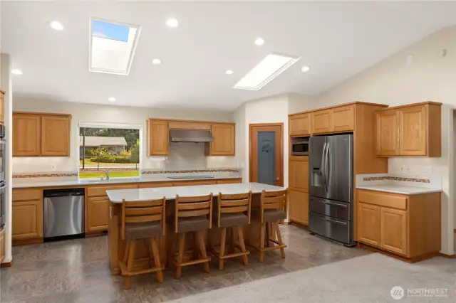 The kitchen is a chef's delight. The large island makes a great seating area or workspace. The pantry in the corner holds plenty of kitchen supplies. Kitchen features stainless steel appliances. There is a shelf for a microwave oven.