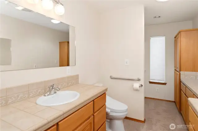 The main bathroom features double sinks and a walk in shower. Plenty of cabinets for storage.
