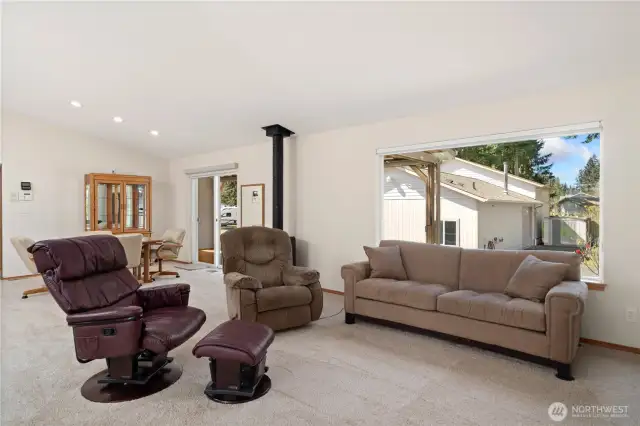 Spacious living room features a large window that has blinds and also sun shades that you can see out but block the sun on sunny days.