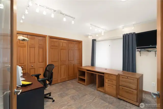 Large office with closets with several storage shelves.