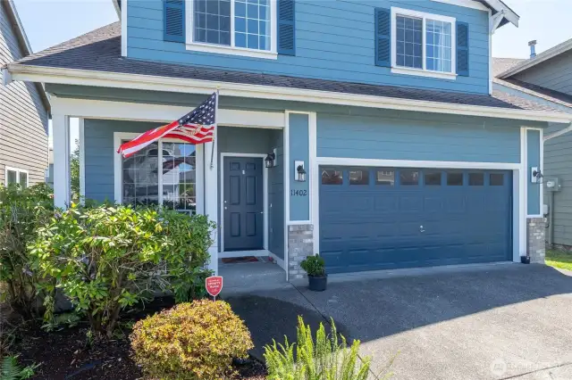 Inviting front entrance with stone accent details and flag display