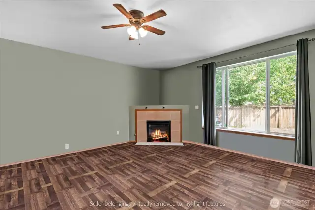 Living room from corner highlighting fireplace, large windows and backyard view
