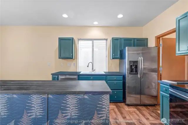 Updated kitchen with teal cabinets, newer stainless steel appliances, and walk-in pantry