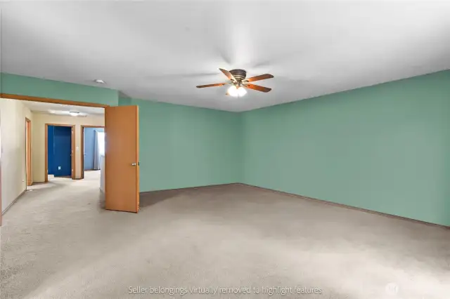 Huge primary bedroom with mint green walls and ceiling fan