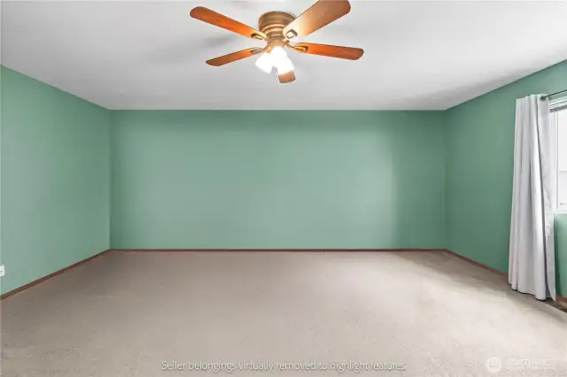 Primary bedroom detail with window treatments and ceiling fan