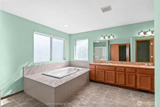 Primary bathroom with soaking tub and dual vanity setup