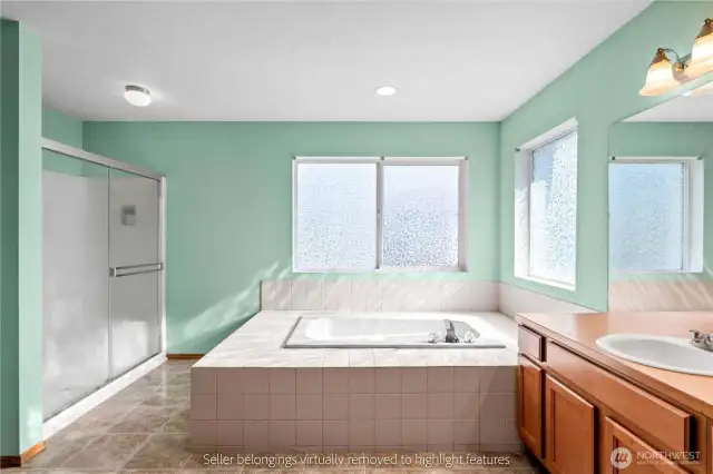 Primary bathroom view with tiled tub surround and fixtures