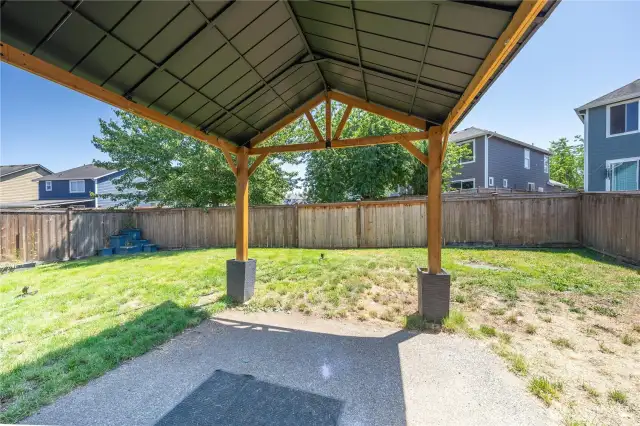 Backyard gazebo on concrete pad with fully fenced yard