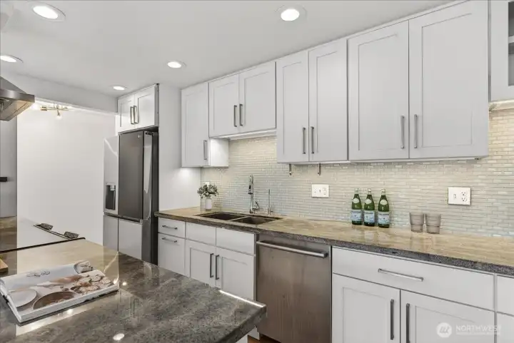 Bright and beautifully updated kitchen featuring sleek cabinetry, stone countertops, and generous prep space designed for both everyday living and effortless entertaining