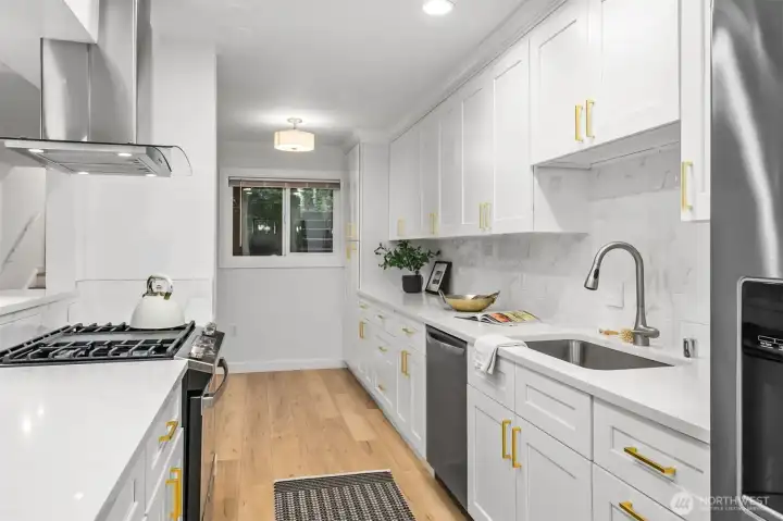 A beautifully updated kitchen featuring abundant counter space, ample cabinetry for storage, fresh modern finishes, and an open breakfast bar perfect for casual dining.