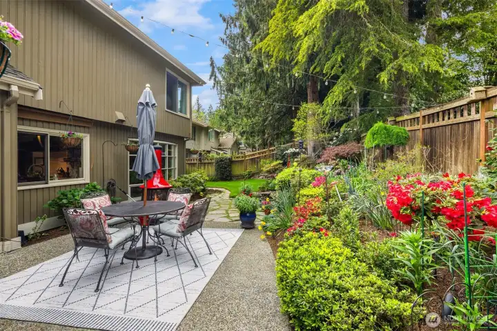 Trimmed hedges, flowering plants, and mature trees that provide shade and privacy