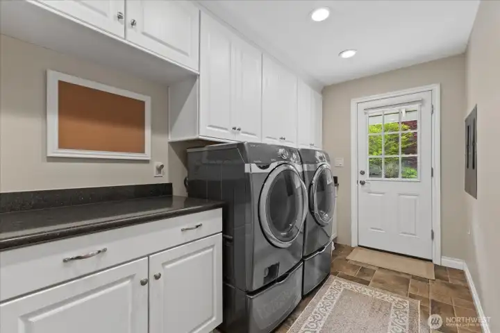 Laundry room with abundant storage and generous counter space.