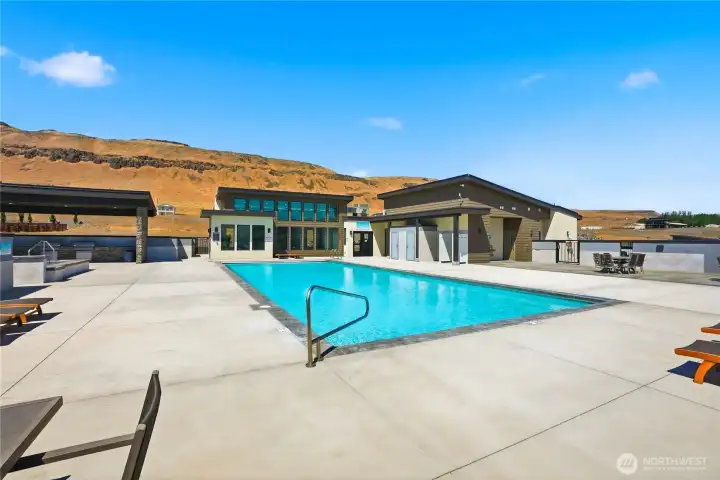 Pool has lounge chairs, tables bathrooms and showers