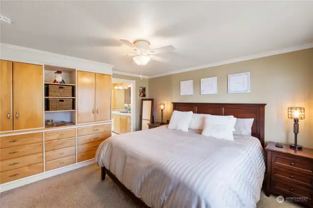 Upstairs primary suite featuring built ins and attached bath with dual vanities, walk in closet and shower