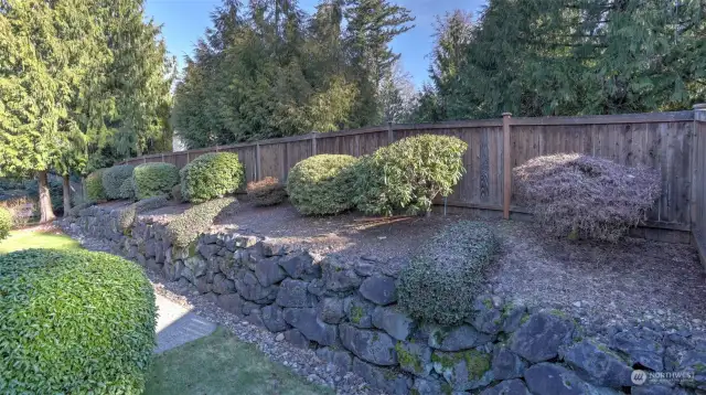 This angle showcases the lush greenery, trees, and plants surrounding the home, enhancing the natural beauty and PNW feel of the property.