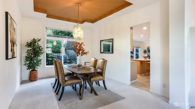 Enjoy dining in this room with scenic nature views to the backyard, stunning tray ceiling that accentuates the chandelier, and convenient access to the kitchen.