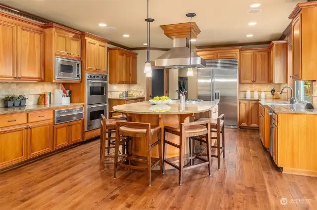 The Chef's kitchen ~ massive granite seating/prep island, SubZero refrigerator, a full Viking appliance package including double ovens, warming drawer, and a commercial-grade 6-burner range and vent hood, along with abundant cabinet and countertop space.