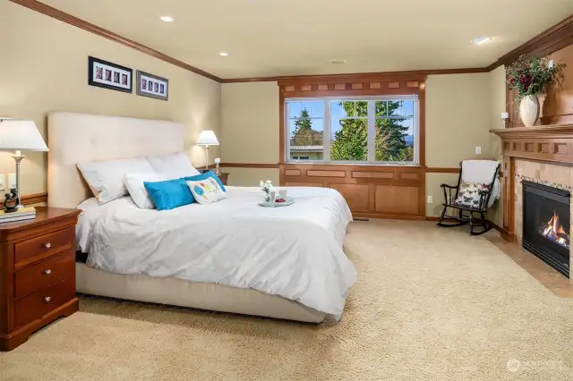 The elegant and relaxing primary suite offers a fireplace and inspiring sunsets, views of the Seattle skyline and Olympic Mountains on clear days.