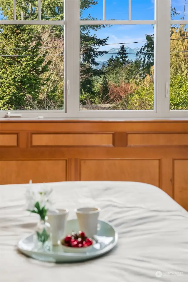 The elegant and relaxing primary suite offers a fireplace and inspiring sunsets, views of the Seattle skyline and Olympic Mountains on clear days.