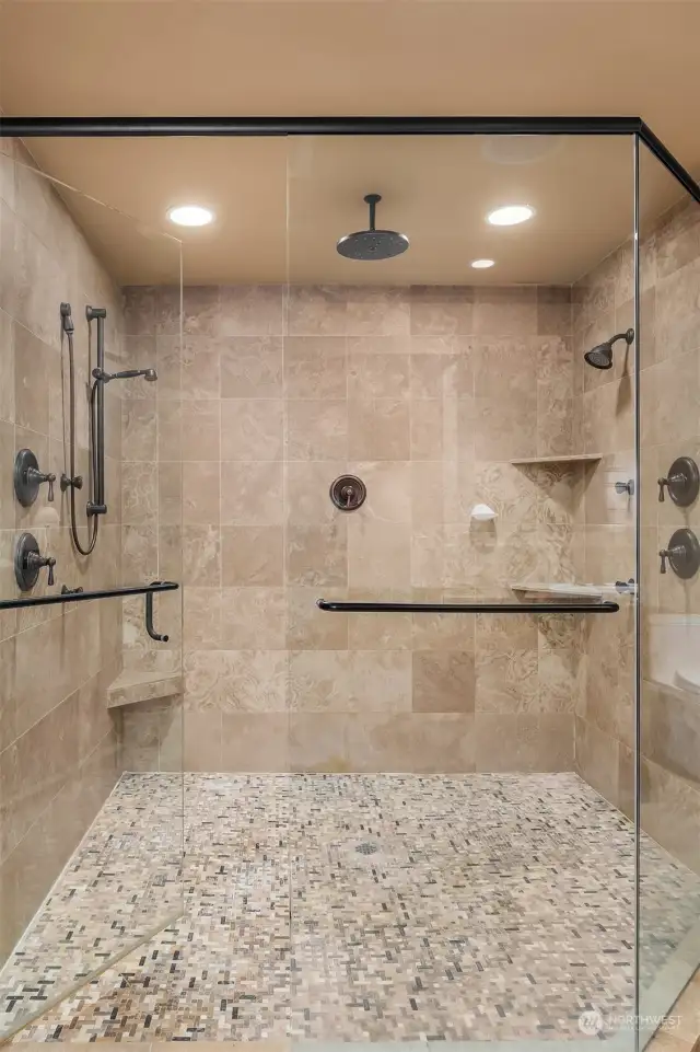 The large en suite spa-inspired bath with frame-less glass door double shower, Travertine tilework, heated floors, jetted tub, and huge cedar-lined walk-in closet.