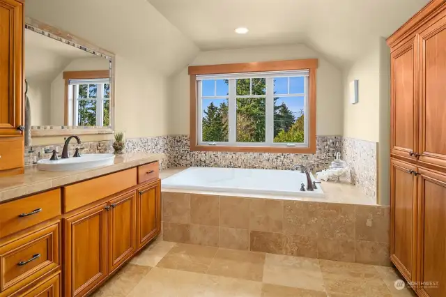 The large en suite spa-inspired bath with frame-less glass door double shower, Travertine tilework, heated floors, jetted tub, and huge cedar-lined walk-in closet.