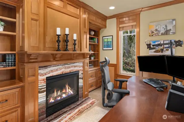 The office / library displays the elegant and warm craftsmanship of the home with a fireplace wrapped in polished marble tile, a stunning mantle and built in cabinets and shelves.