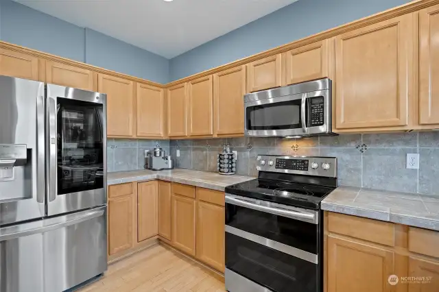 Kitchen features stainless steel appliances, pantry, and tile countertops.