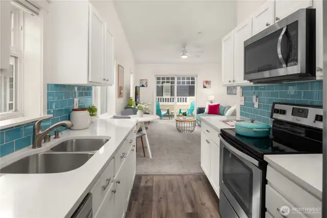 Undermount sink, glass tiled backsplash, overhead microwave and new cabinetry.