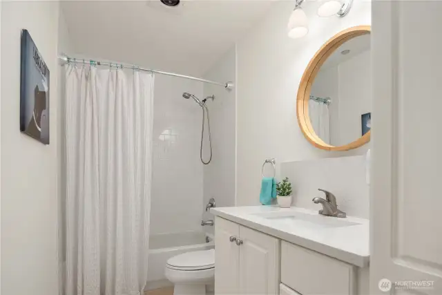 The full size tiled bath has great storage with an overhead skylight.