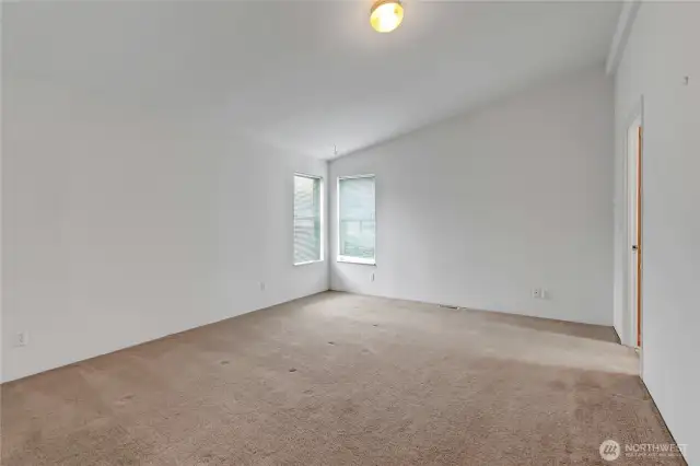 Primary suite that is currently unfurnished. Bath is through the doorway to the right.