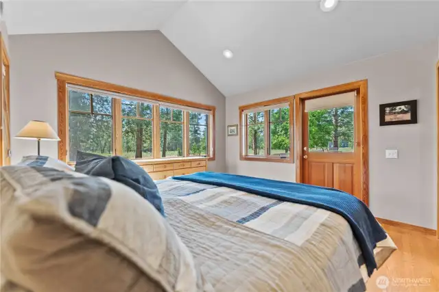 Primary bedroom invites quiet  relaxation and contemplation! Door opens onto sunny deck so you can sneak out for morning sunshine before the rest of the house wakes up!