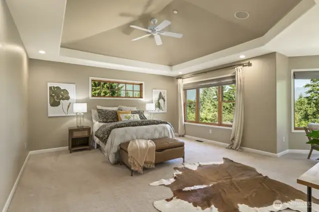 French doors open to the expansive primary bedroom with vaulted coffered ceiling, custom blinds and spectacular views.