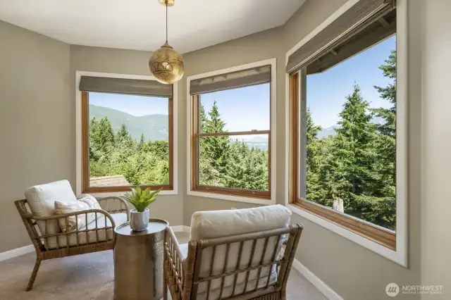 The primary suite is a serene retreat featuring a cozy sitting area, walk-in closet, spa-like bath and jaw-dropping views.