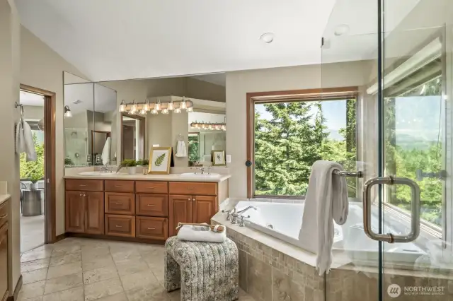Light-filled spa retreat featuring double vanities, a corner soaking tub framed by windows, and a spacious walk-in shower—your perfect place to unwind.