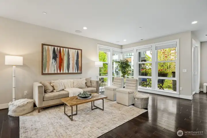 Open, light-filled living space with soaring ceilings and expansive floor to ceiling windows