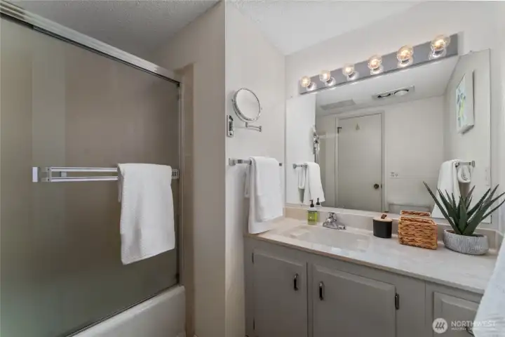 Bathroom 1 with bath and shower and large vanity.