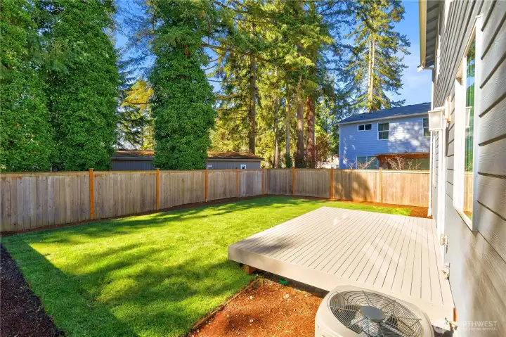 Lush green grass and  fenced backyard