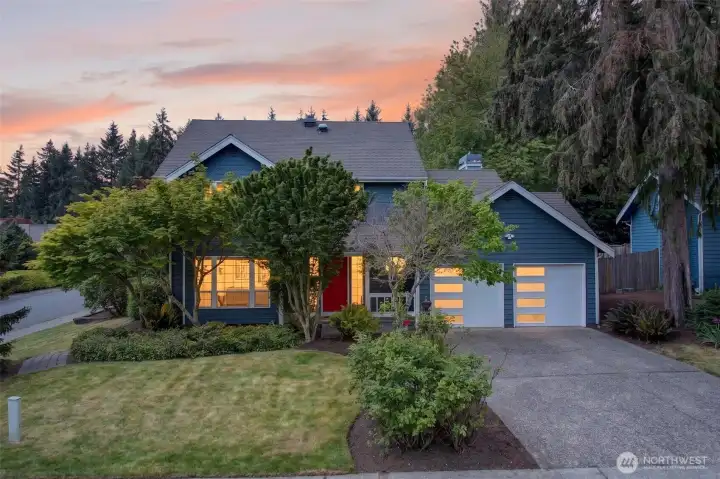 Set against a glowing Sunrise sky on English Hill, this Sunrise neighborhood two-story radiates the kind of warmth that turns the drive home into something to look forward to. Mature landscaping, the signature red door, and modern frosted-glass garage doors installed in 2025 give it standout curb presence on a coveted Redmond street.