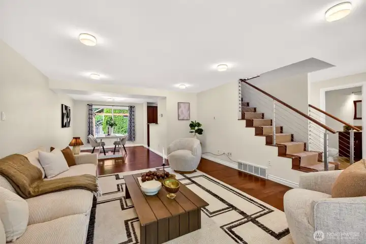 Updated hardwoods, the striking cable-rail staircase, and an open sightline to a sunlit dining nook create a sophisticated yet comfortable gathering space. The thoughtful layout allows multiple zones for relaxing, dining, and connecting without feeling closed in.