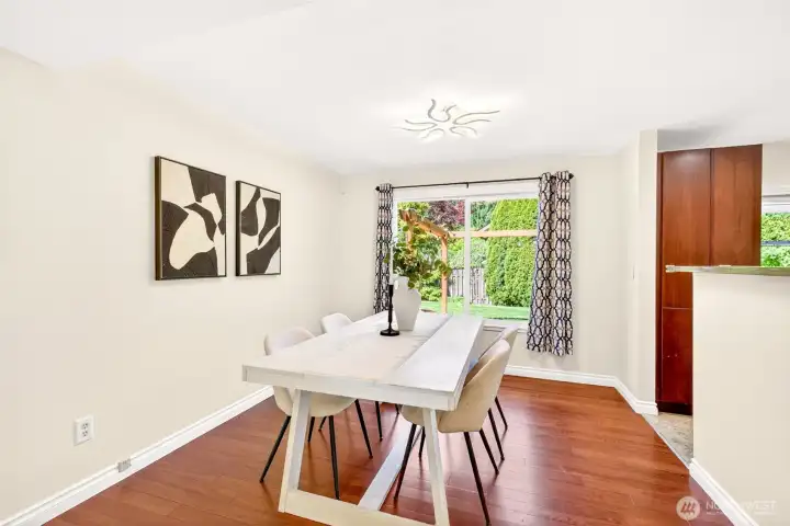The dedicated dining room enjoys garden views through a window that showcases views of the backyard pergola, inviting sunlight in to the open space. Updated hardwoods and a modern statement light fixture elevate the space well beyond the home's original era.