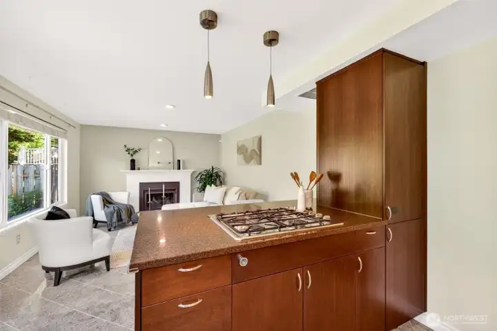 The peninsula opens directly into the cozy family room, where a white brick gas fireplace creates an inviting focal point for chilly Pacific Northwest evenings. Conversations flow naturally between cook and relaxation, making this the true gathering hub of the home.