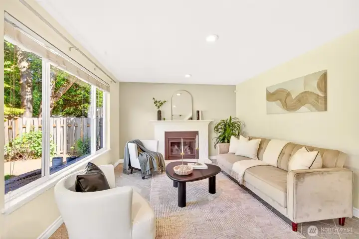 The family room offers a warm, intimate retreat anchored by the white brick gas fireplace, with picture windows framing the leafy, fully-fenced backyard. It's the perfect spot to unwind with a book or host casual movie nights once the day winds down.