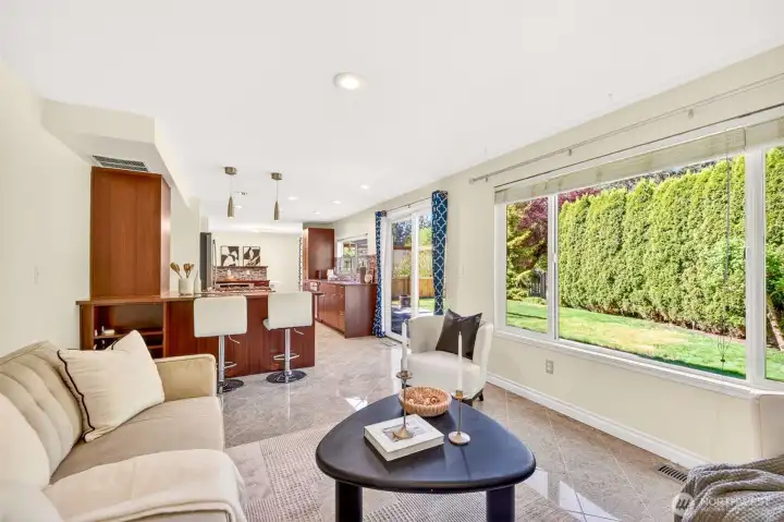 The family room extends seamlessly to the backyard through a slider, with expansive windows showcasing the lush evergreen hedge that provides natural privacy year-round. Updated counter-height seating at the peninsula keeps the cook engaged with everyone enjoying the view.