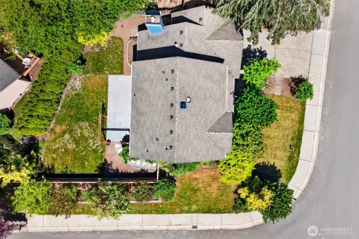 An overhead aerial reveals the home's generous 7,314 square-foot lot, the expansive patio, and the dense privacy hedge that wraps the rear and side yards. The corner-style positioning at the end of a quiet street gives the property a uniquely private feel rare for the Sunrise neighborhood.