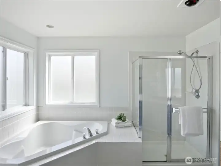 Generous ensuite thoughtfully designed featuring a deep soaking tub and a separate shower.