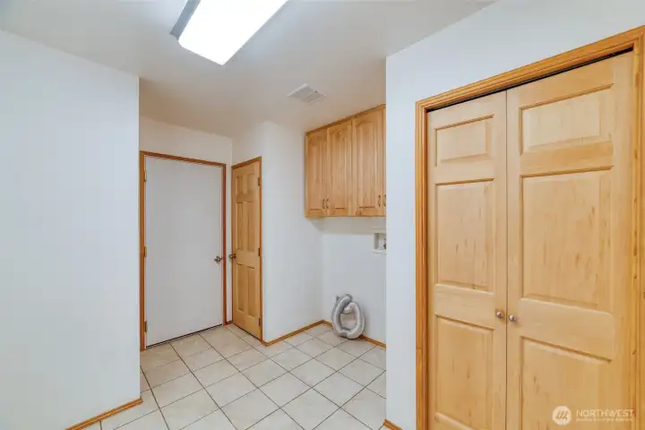 Large laundry room with additional storage leading to the attached garage. Large laundry room with additional storage leading to the attached garage.