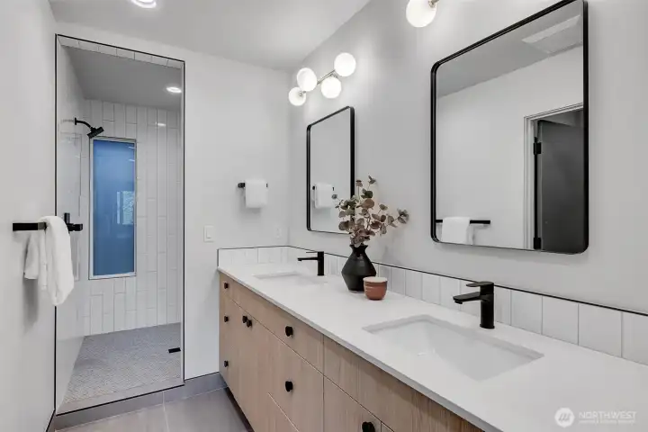 Modern ensuite featuring dual sinks, matte-black fixtures and large walk in shower. Modern ensuite featuring dual sinks, matte-black fixtures and large walk in shower.