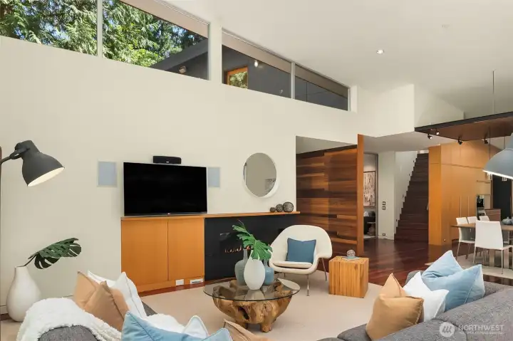 Warm wood tones carry through the main level — cedar accent walls, fir cabinetry, and the staircase rising to the upper floor.
