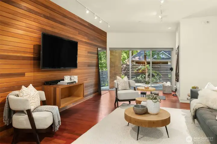 A separate family room off the entry offers flexible space for media, play, or guests, with the same cedar paneling and sliding doors to a private side patio.